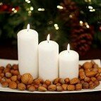 Centro de mesa navideño con velas y frutos secos